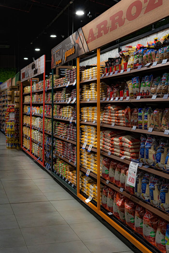 A grocery store aisle filled with various rice and grain packages neatly organized on shelves.